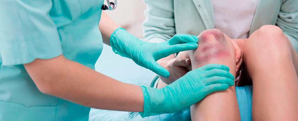 un médico examina una lesión en la rodilla